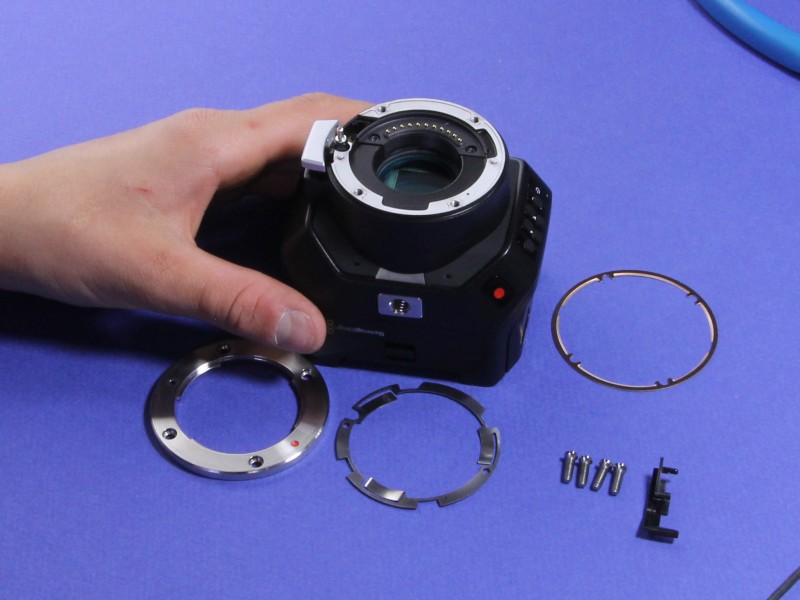 White shim seated beneath the camera electrical contact block